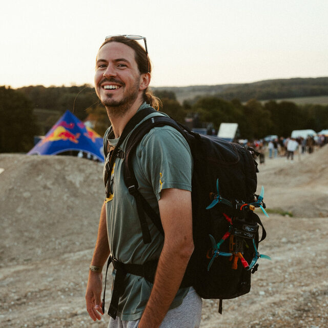 Robin Cretinon, cinéaste et pilote FPV, avec son sac à dos en montagne